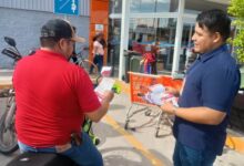 Personal de la SSP entrega volantes de la Jornada Contra la Extorsión y Robo de Vehículos a un motociclista en Chedraui Álamo