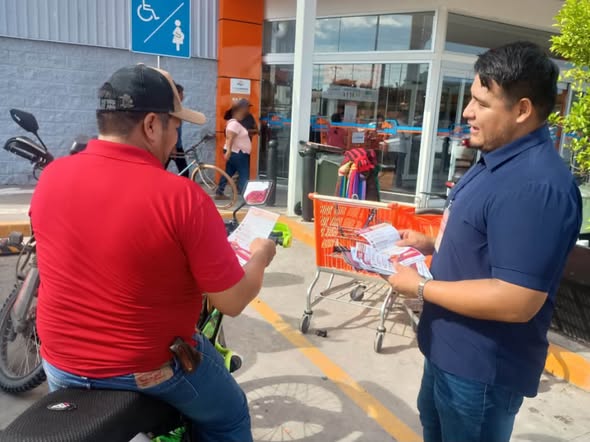 Personal de la SSP entrega volantes de la Jornada Contra la Extorsión y Robo de Vehículos a un motociclista en Chedraui Álamo