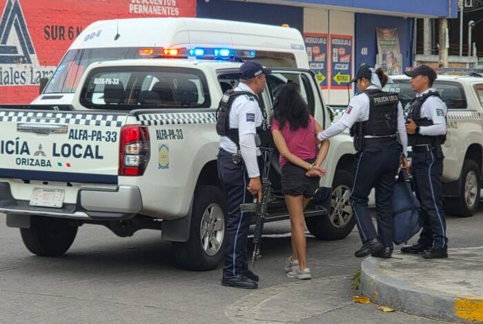 Mujer detenida junto a una patrulla de la Policía Municipal de Orizaba