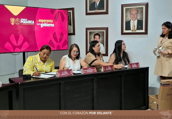 La síndica única de Cazones, Joselin Escalona Cruz, firma los documentos del convenio con la CEDHV en la mesa del presidium