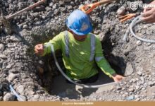 Trabajador de la Coordinación de Agua y Saneamiento repara una fuga de agua dentro de una zanja en Tuxpan