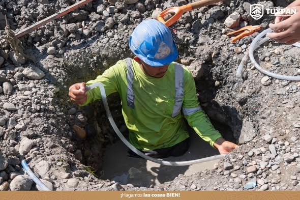 Trabajador de la Coordinación de Agua y Saneamiento repara una fuga de agua dentro de una zanja en Tuxpan