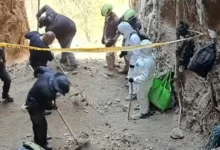 Personal forense con trajes de protección trabaja en una excavación acordonada