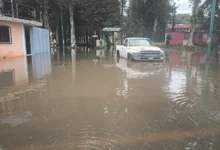 Calle inundada en Xalapa con el agua cubriendo la vialidad tras las lluvias de este domingo
