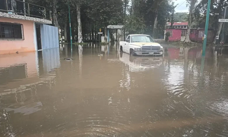 Calle inundada en Xalapa con el agua cubriendo la vialidad tras las lluvias de este domingo
