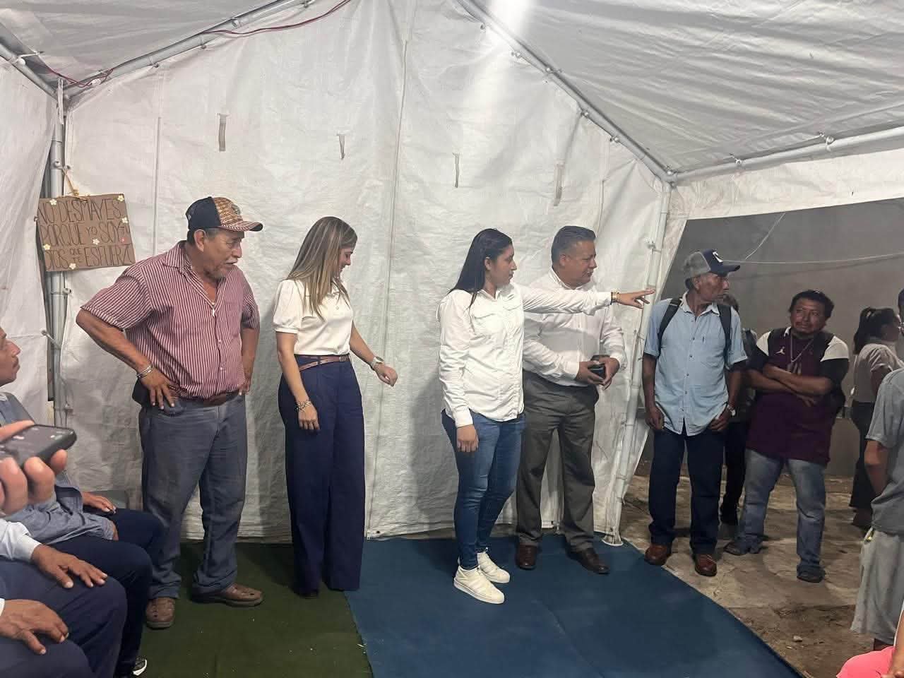Carpa con letrero y personas