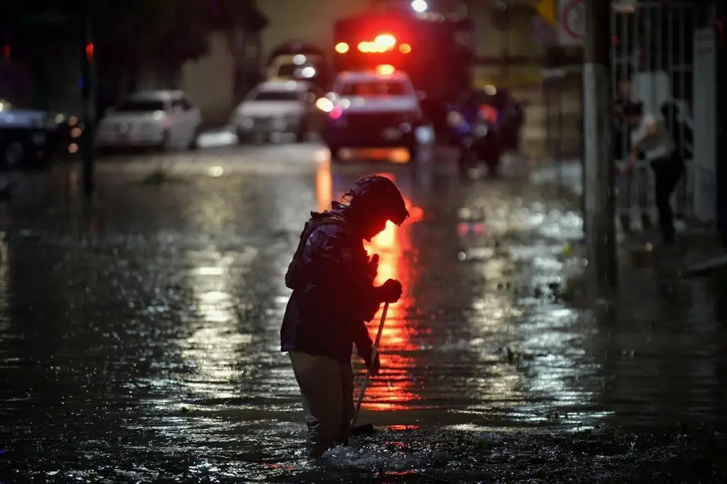 Calle inundada de noche en Xalapa con rescatista de Protección Civil durante las lluvias del 28 de septiembre de 2026