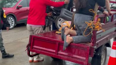 Familias afectadas por las inundaciones siendo auxiliadas para subir a una camioneta de plataforma bajo la lluvia, en Álamo Temapache