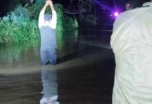 Vecino dentro del agua en el arroyo de Mequetla, Álamo, durante la crecida nocturna