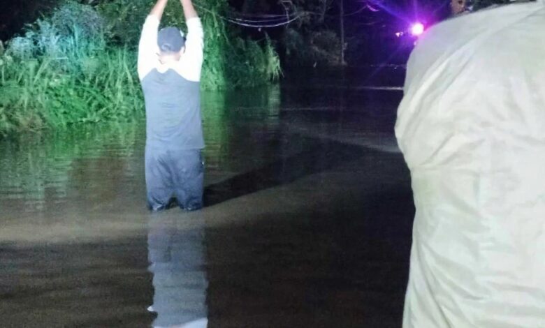 Vecino dentro del agua en el arroyo de Mequetla, Álamo, durante la crecida nocturna
