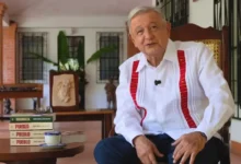 Andrés Manuel López Obrador sentado durante la presentación de su libro Pueblo, con ejemplares de Grandeza y Pueblo sobre la mesa.