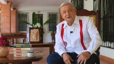 Andrés Manuel López Obrador sentado durante la presentación de su libro Pueblo, con ejemplares de Grandeza y Pueblo sobre la mesa.