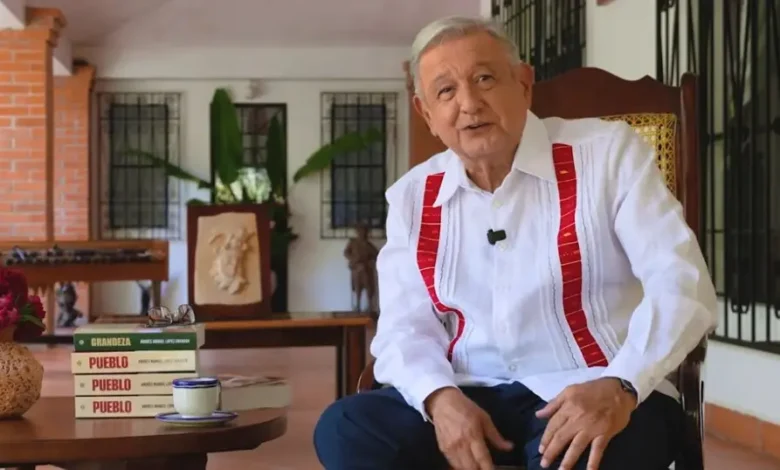 Andrés Manuel López Obrador sentado durante la presentación de su libro Pueblo, con ejemplares de Grandeza y Pueblo sobre la mesa.