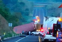Contenedor rojo volcado atravesado sobre la autopista Cardel-Poza Rica; fila de vehículos detenidos detrás