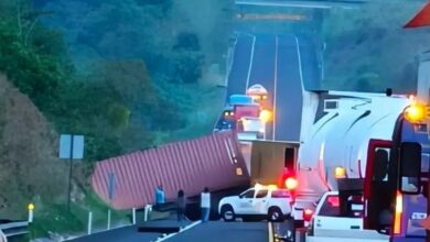 Contenedor rojo volcado atravesado sobre la autopista Cardel-Poza Rica; fila de vehículos detenidos detrás