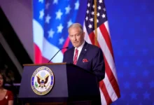 El embajador de Estados Unidos en México, Ronald Johnson, durante un mensaje desde el podio de la Embajada estadounidense en la Ciudad de México, con banderas de su país al fondo.