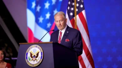 El embajador de Estados Unidos en México, Ronald Johnson, durante un mensaje desde el podio de la Embajada estadounidense en la Ciudad de México, con banderas de su país al fondo.