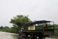 Camión del Ejército Mexicano con soldados y lona del Plan DN-III-E en carretera bajo lluvia en el norte de Veracruz