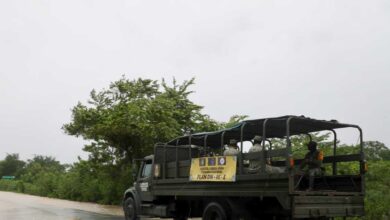 Camión del Ejército Mexicano con soldados y lona del Plan DN-III-E en carretera bajo lluvia en el norte de Veracruz