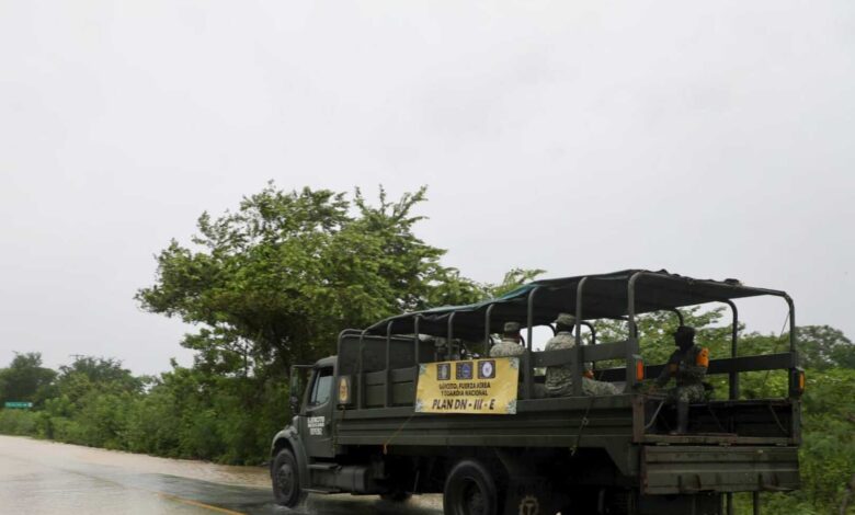 Camión del Ejército Mexicano con soldados y lona del Plan DN-III-E en carretera bajo lluvia en el norte de Veracruz