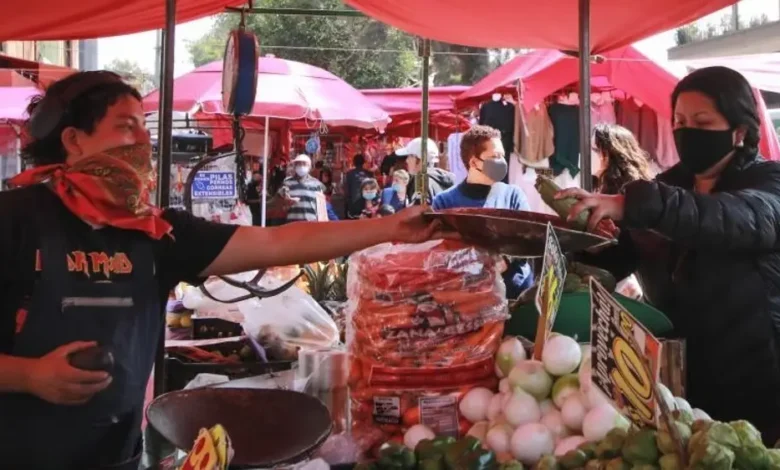 Puesto de mercado con frutas y verduras y clientes comprando
