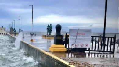 Olas rompen contra el malecón bajo cielo nublado; Protección Civil mantiene la Alerta Gris