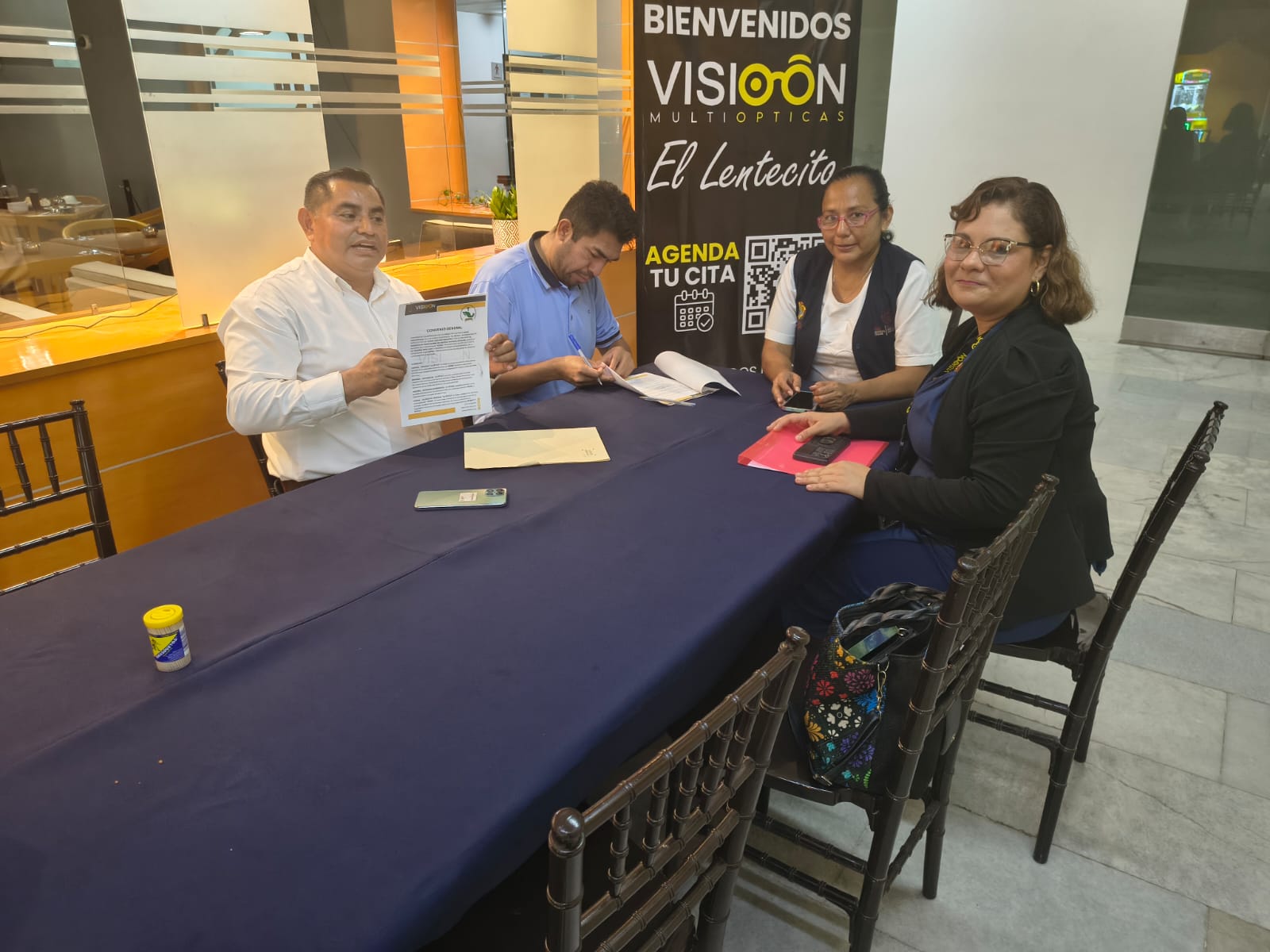 Representante del STSNS muestra el documento del convenio firmado