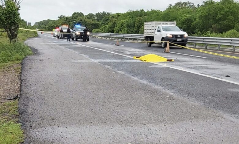 Carretera acordonada con cinta amarilla; patrullas y una lona amarilla sobre el cuerpo