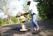 Trabajador compacta el bacheo en una carretera de Tantima