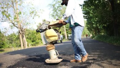 Trabajador compacta el bacheo en una carretera de Tantima