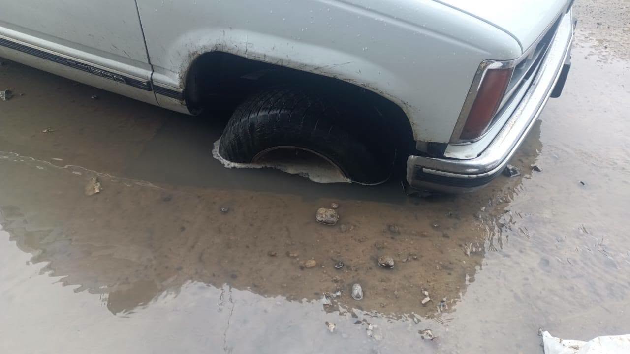 Acercamiento de la llanta sumergida en el hoyo con agua, calle Cuitlahuac, Tuxpan